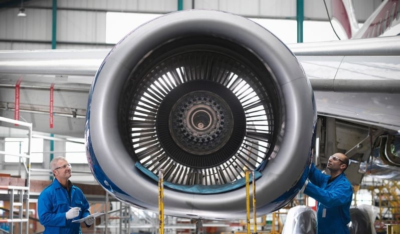 A photo of aircraft engineers working on a jet engine 